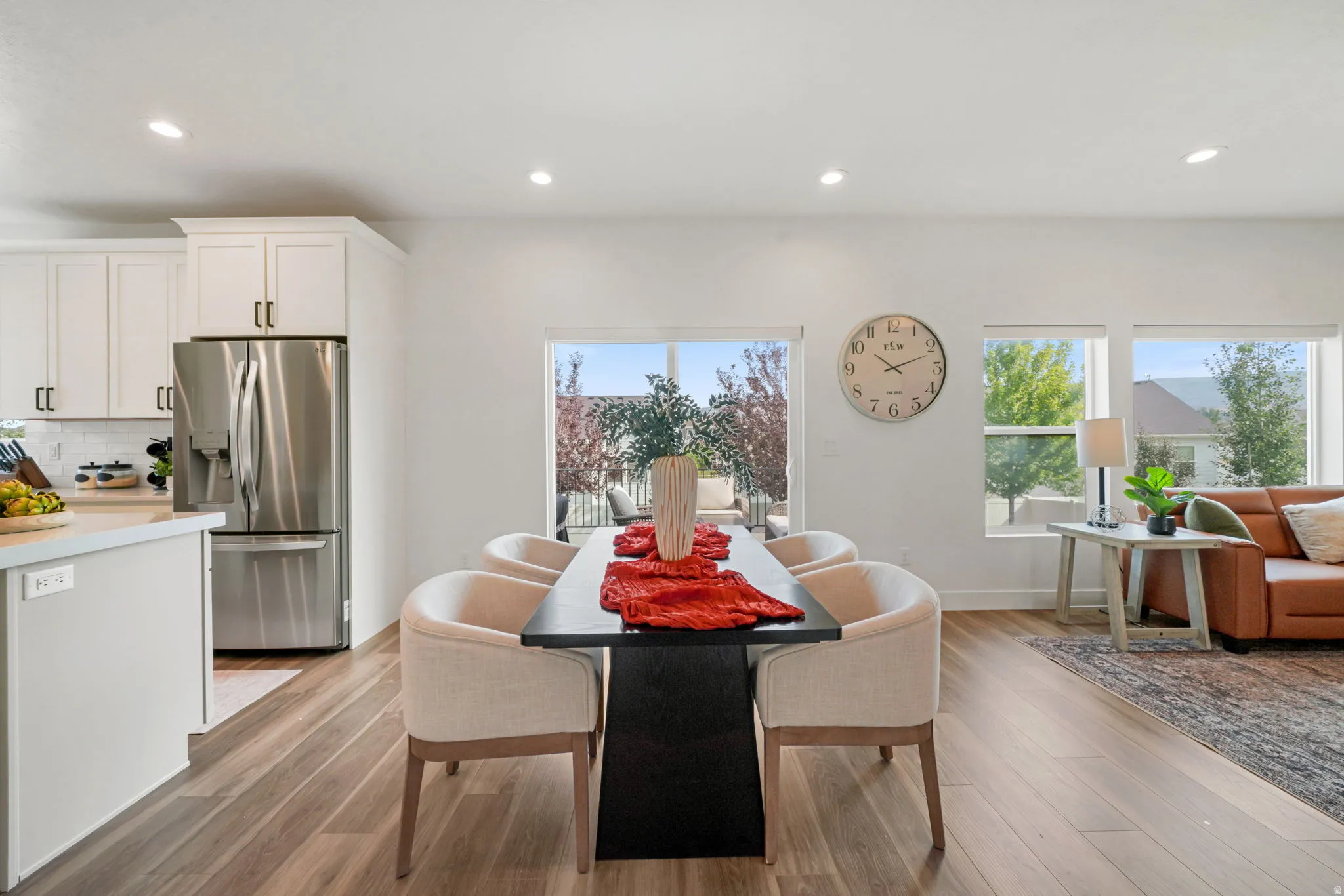Open-concept living space with wood-finish flooring, recessed lighting, and expansive windows