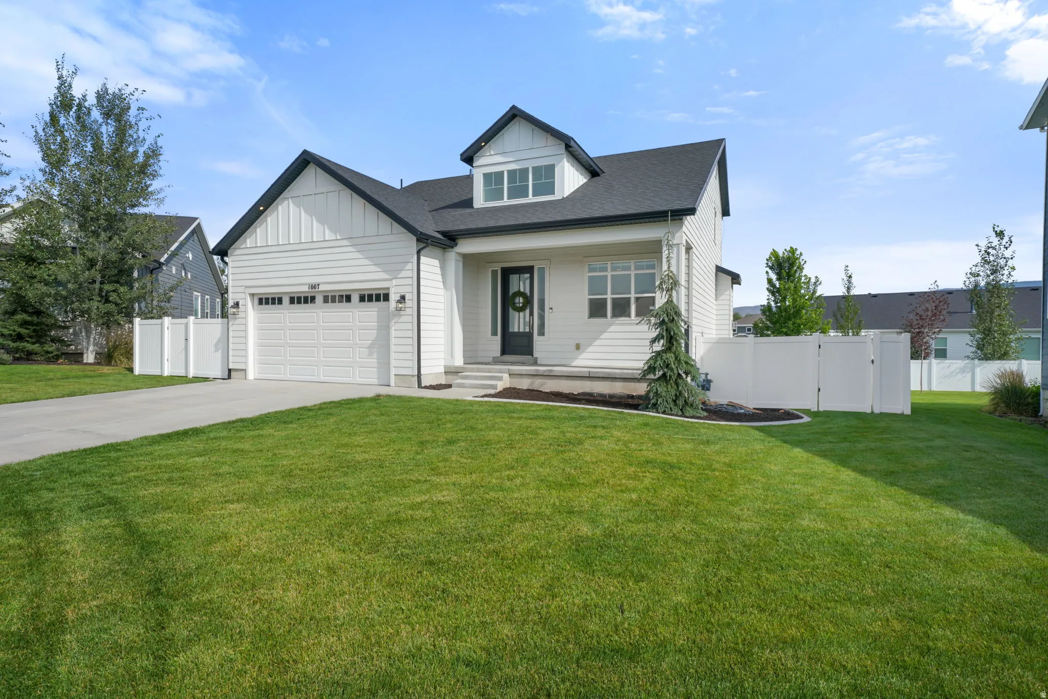 Modern farmhouse exterior with white vertical siding and dark trim