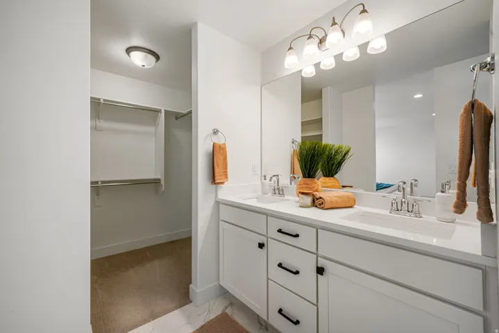 Spa-inspired primary bathroom featuring a dual-sink vanity with soft-close cabinetry, white quartz countertop, and chrome fixtures