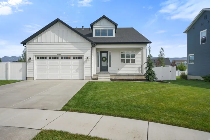 Charming two-story home featuring a classic gabled roofline with decorative cross bracing, a prominent front-facing dormer with dual windows, and a four-car garage with paneled doors