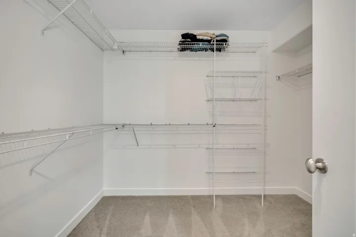 Walk-in closet featuring wire shelving, wire hanging rods, and an integrated wire basket system
