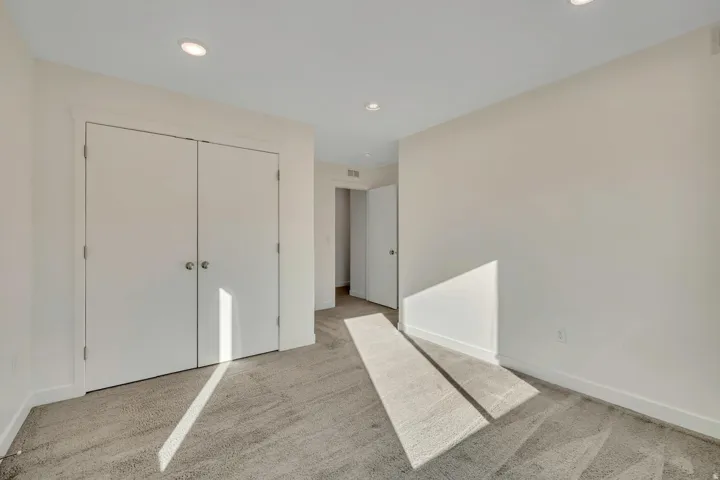 Recessed lighting, white walls, gray carpeting, and white trim