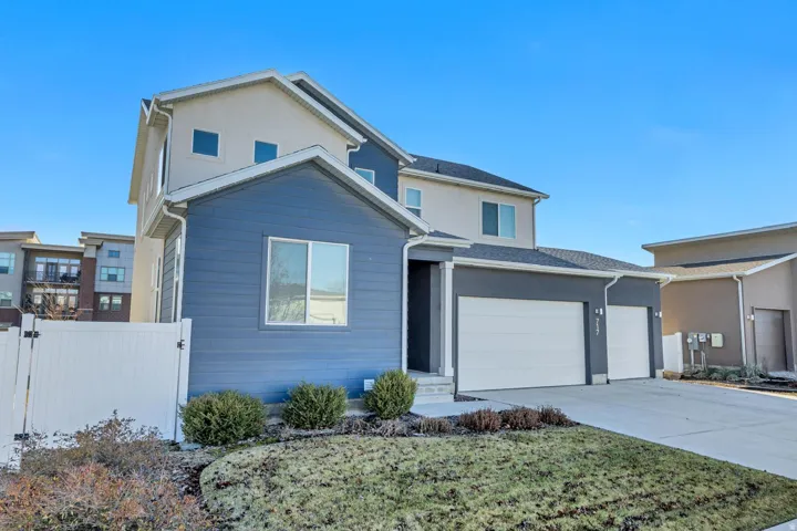 Two-story residence featuring a multi-tone exterior, attached two-car garage, and a concrete driveway