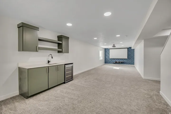 Wet bar featuring upper and lower cabinetry, countertop, and integrated beverage refrigerator
