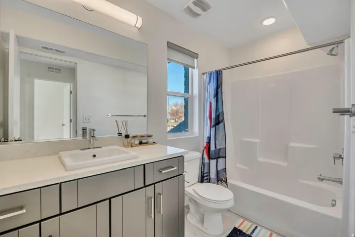 White vanity with rectangular sink, polished chrome faucet, and integrated storage