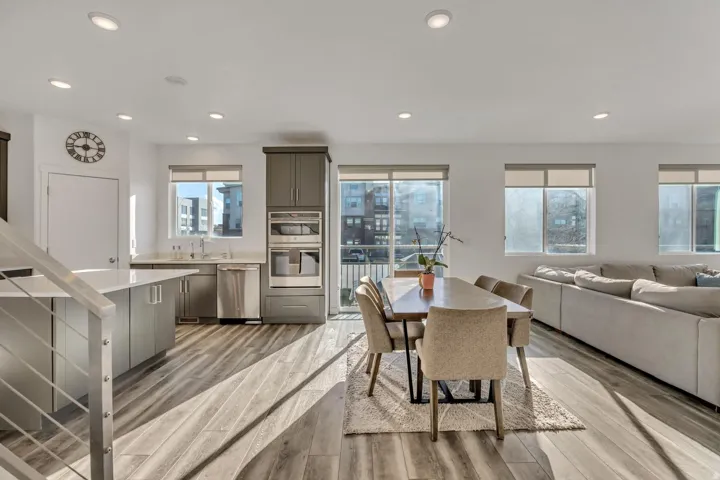 Open-concept living space with wood-finish flooring, recessed lighting, and expansive windows