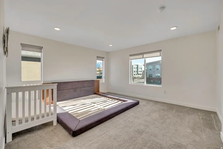 Room with recessed lighting, multiple windows, and light-toned carpeting