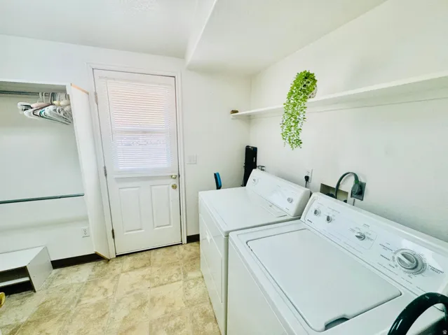 Laundry area featuring a windowed door, built-in shelving, a clothes rod, and tile flooring
