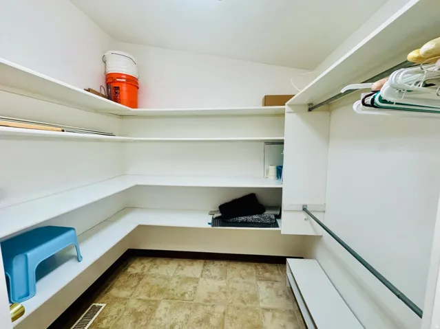 Wraparound shelving, built-in clothing rod, and tile flooring