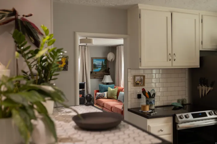 Efficient kitchen layout featuring white cabinetry, subway tile backsplash, and black appliances with cooktop and range