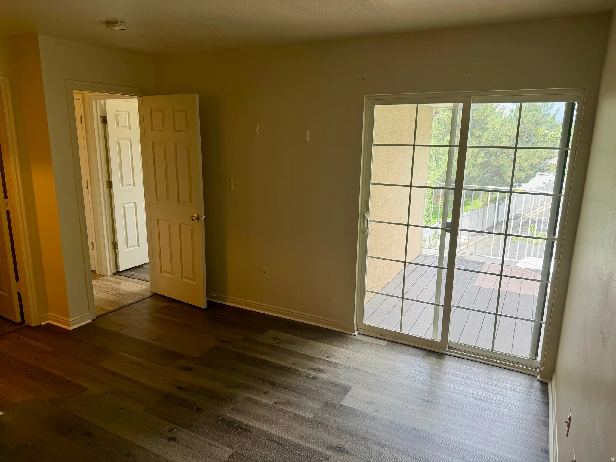 Wood-finish flooring throughout, paired with a sliding glass door offering balcony access