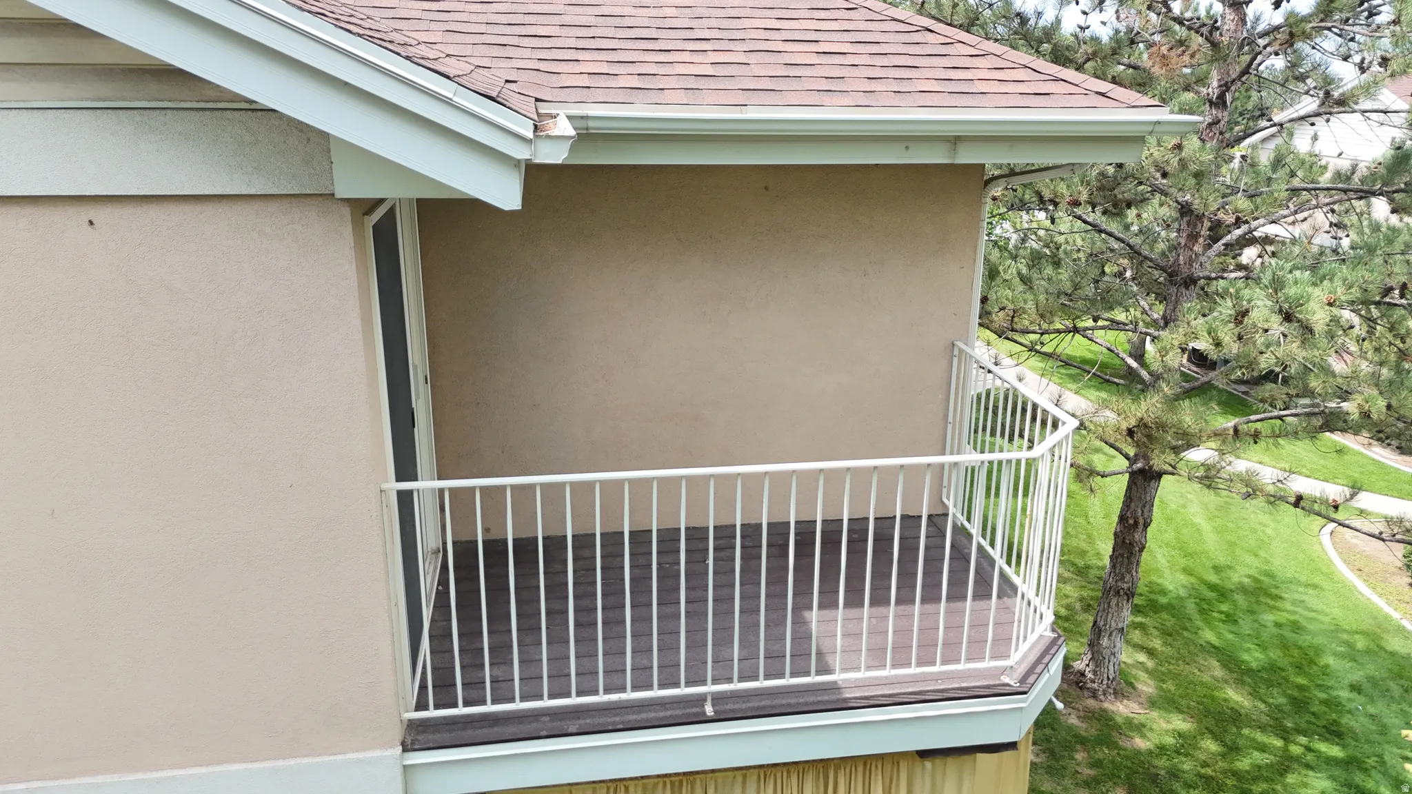 Balcony featuring a railing, wood-finish flooring, stucco exterior, and a shingle roof