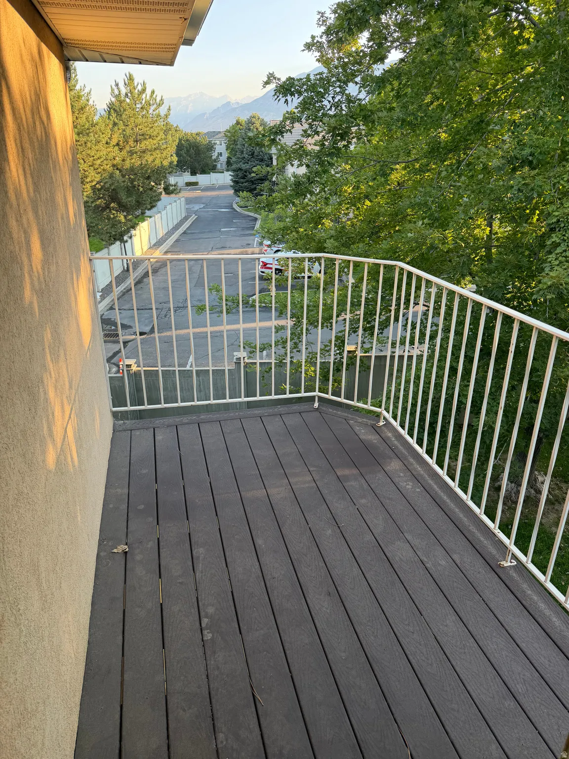 Balcony with composite decking and white metal railing