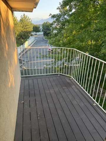 Balcony with composite decking and white metal railing