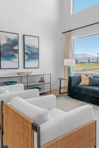 High ceilings, expansive windows, light wood-finish flooring, and a contemporary wall-mounted shelving unit