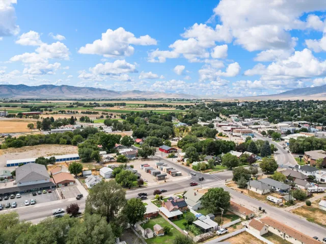 Aerial perspective of a populated area with surrounding agricultural fields and distant mountains