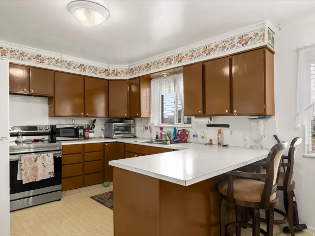 U-shaped kitchen layout with wood cabinetry and light-toned countertops
