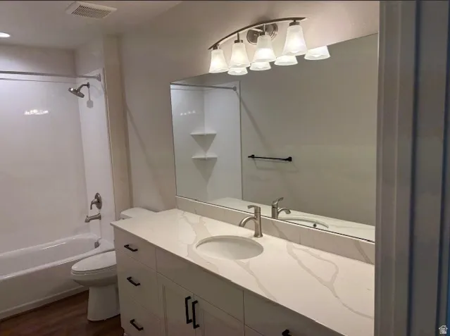 White vanity with black hardware, integrated sink, and stone-finish countertop