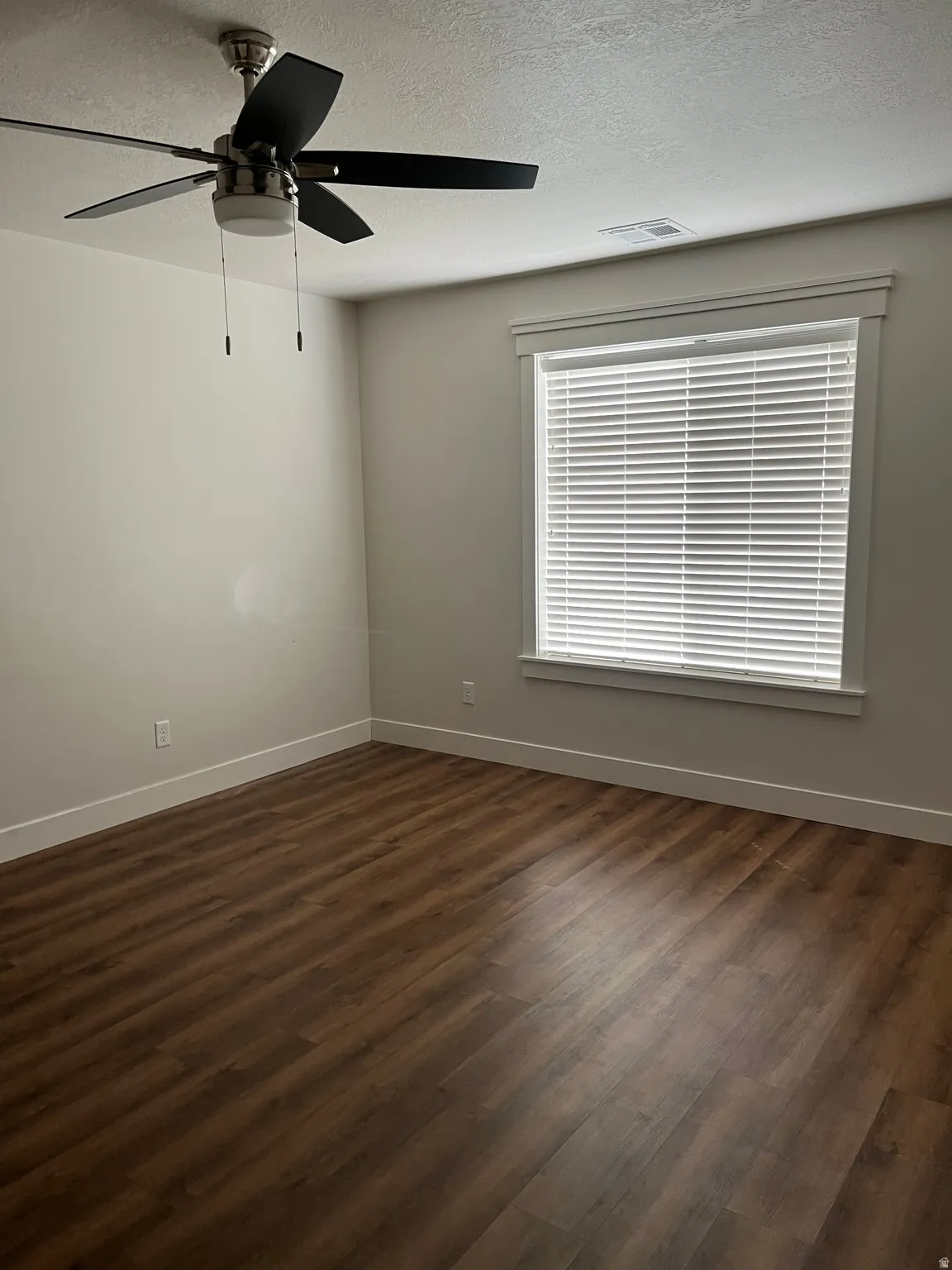 Wood-finish flooring, white window blinds, modern ceiling fan with lighting, and neutral wall paint