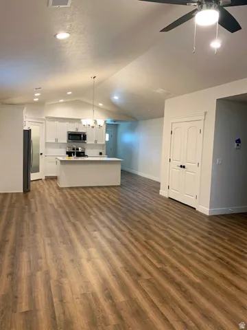 Kitchen with white shaker cabinetry, stainless steel appliances, and a central island
