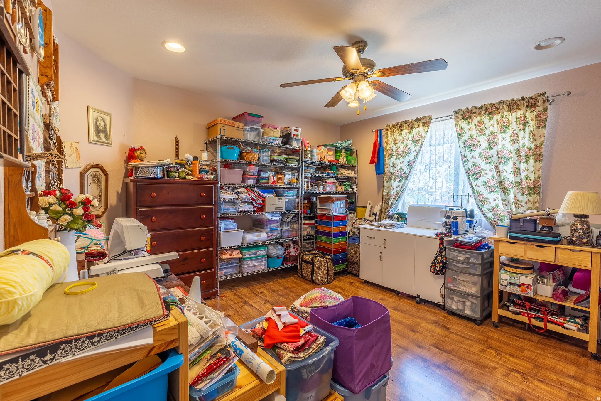 Wood-finish flooring throughout, paired with a ceiling fan and recessed lighting