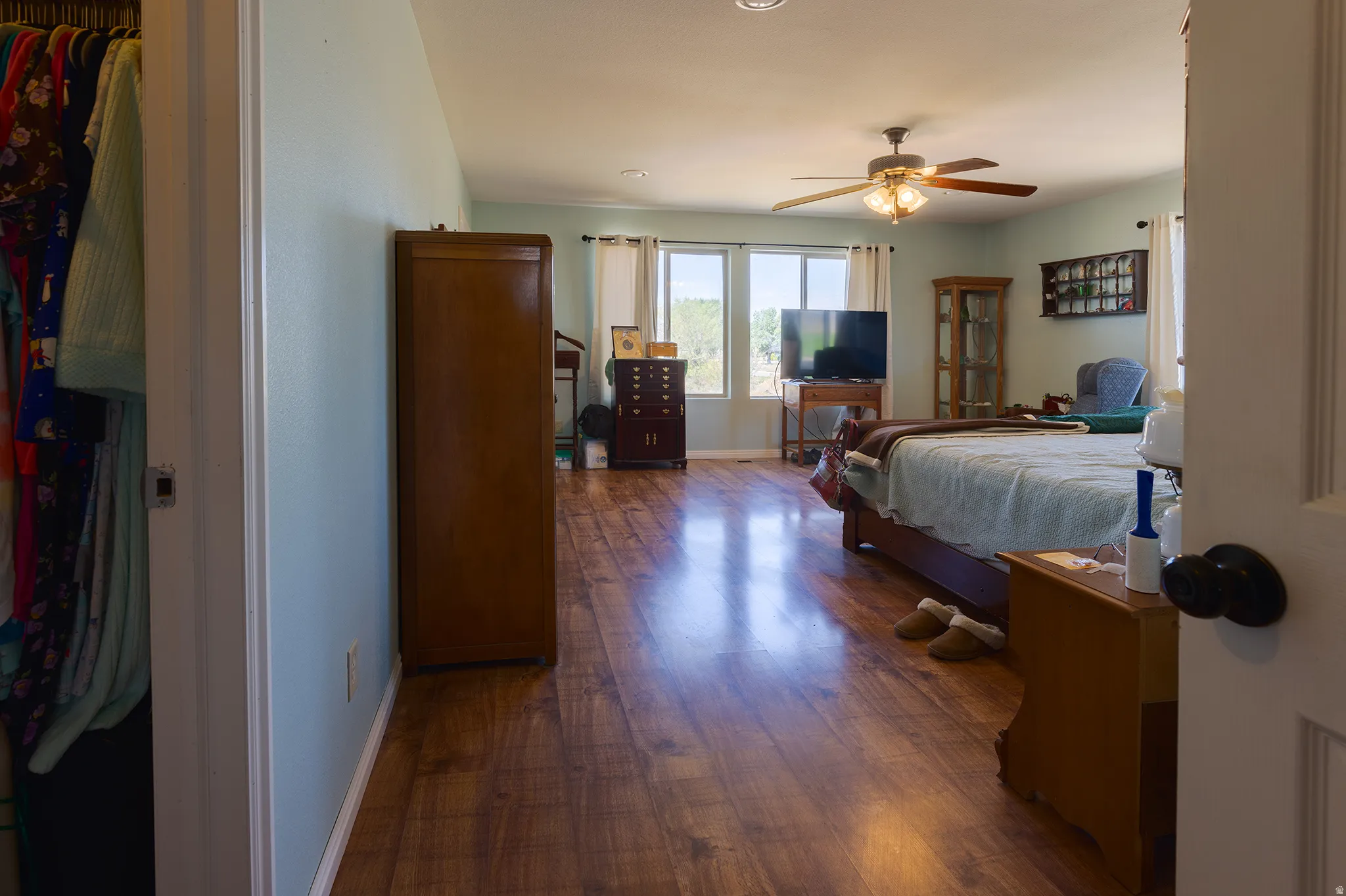 Wood-finish flooring, recessed lighting, ceiling fan, and multiple windows