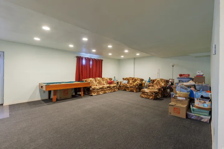 Recessed ceiling lighting, light-colored wall paint, and gray carpet flooring