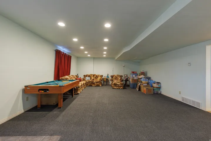 Recessed ceiling lighting, light-colored walls, and gray wall-to-wall carpeting