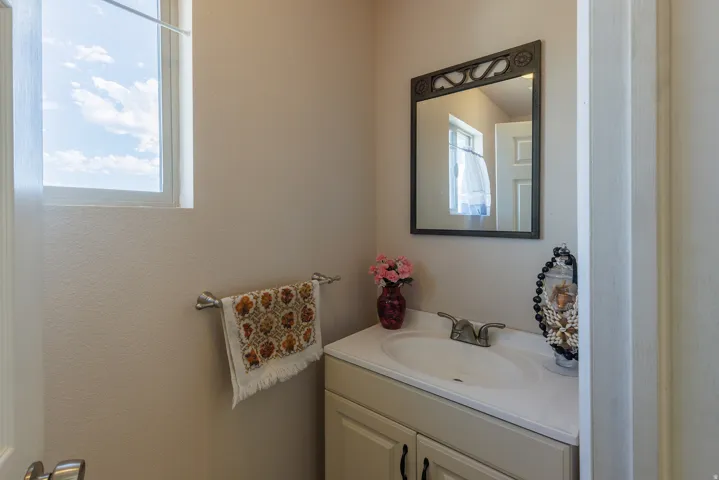 Single vanity with an integrated sink, polished chrome faucet, and cabinet storage