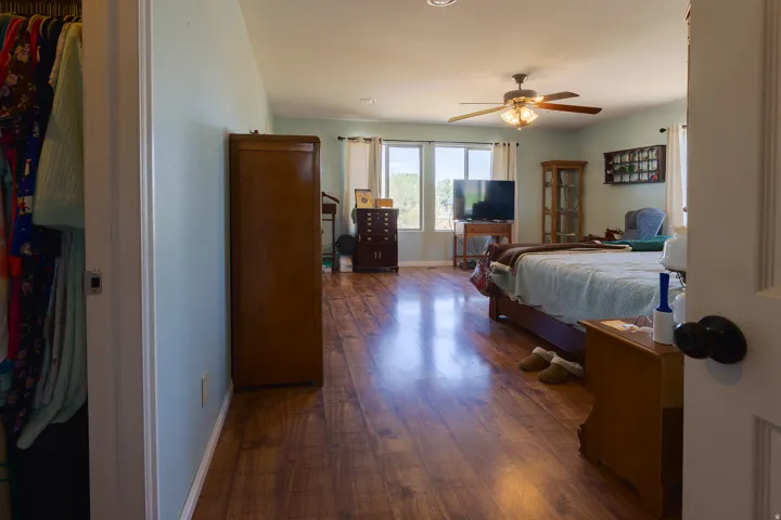 Wood-finish flooring, recessed lighting, ceiling fan, and multiple windows