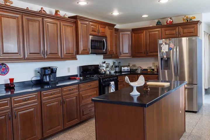 Wood-finish cabinetry with dark countertops