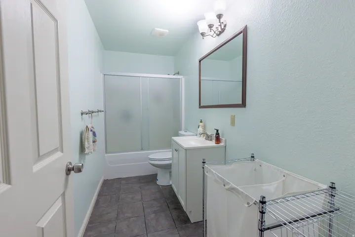 Bathroom with a white vanity, integrated sink, and wall-mounted mirror