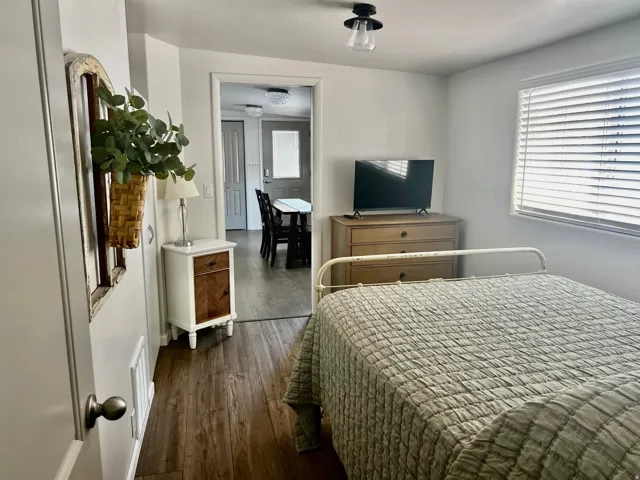 Wood-finish flooring throughout, with a window featuring horizontal blinds