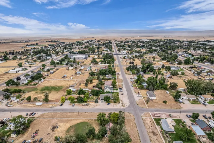 Expansive aerial perspective showcasing a grid street pattern with established residential properties and open land