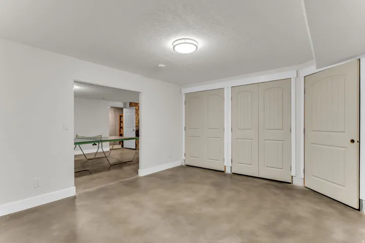Polished concrete flooring, recessed lighting, and multiple closet doors