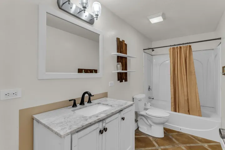 White vanity with a stone countertop and matte black fixtures