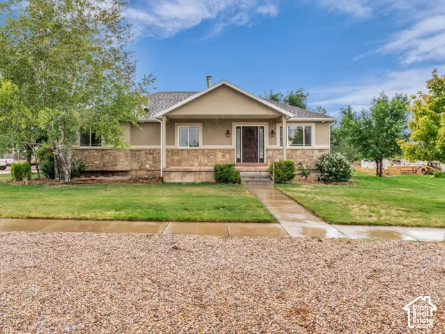 Stucco exterior with stone veneer accents, covered front porch, and a concrete walkway