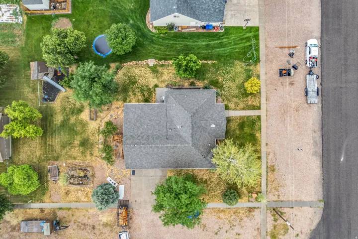 Gable roofline, concrete driveway, concrete sidewalk, mature trees, landscaped front yard