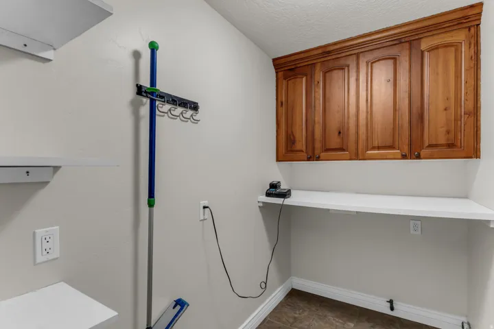 Built-in wood cabinetry, white floating shelves, and a white countertop work surface