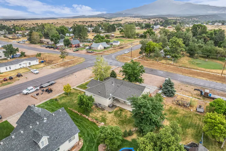Aerial perspective showcasing surrounding landscape, residential properties, and paved roads