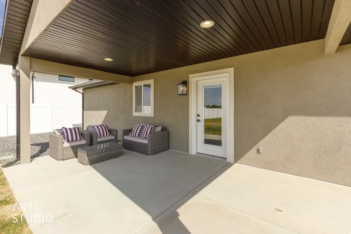 Covered patio featuring a smooth concrete surface, recessed lighting, and an exterior wall sconce