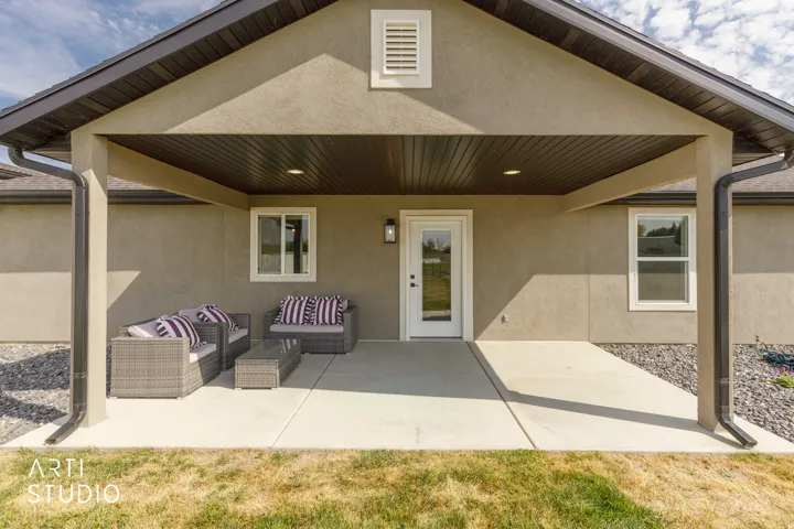 Covered patio with concrete surface, exterior wall sconce, and recessed lighting