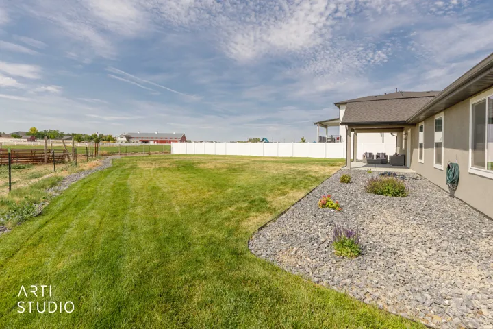Expansive green lawn with a white privacy fence