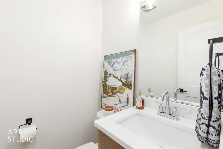 White vanity with integrated sink, chrome faucet, and integrated countertop
