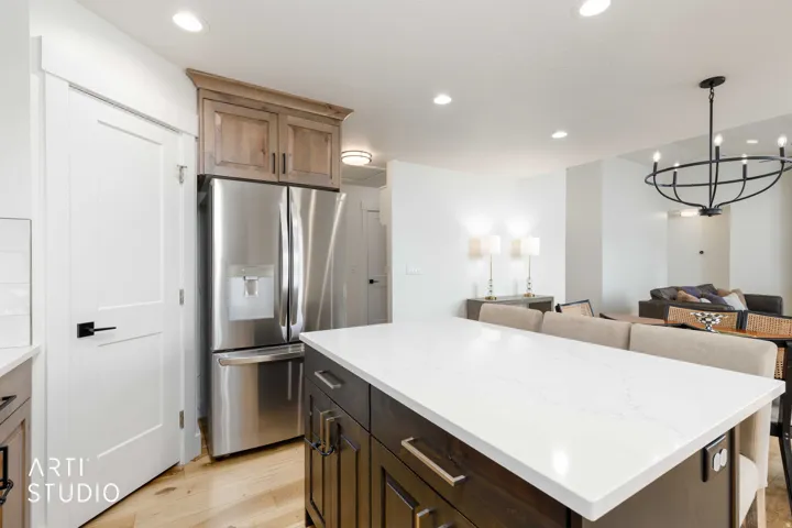 Kitchen island with a white countertop and dark wood-finish cabinetry