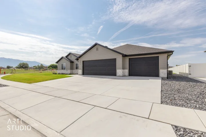 Contemporary exterior with light gray siding, stone accents, and a dark shingle roof