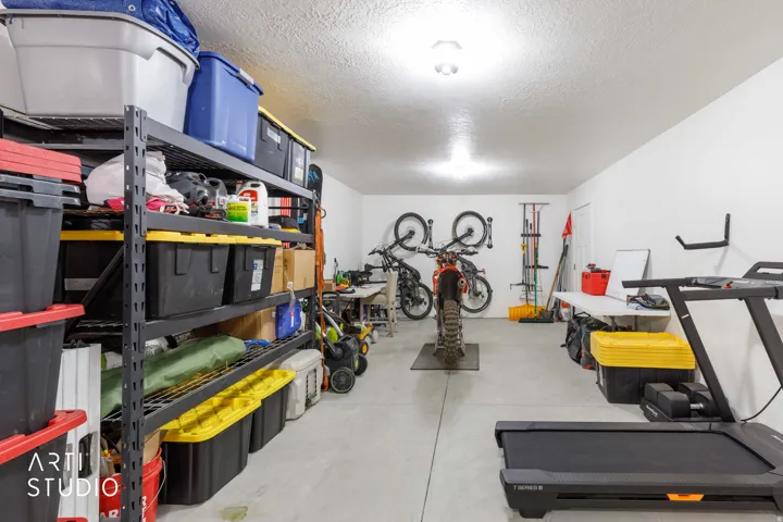 Garage with concrete flooring, white painted walls, and ceiling-mounted lighting