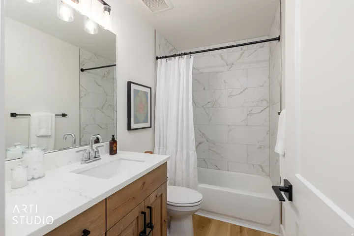 Bathroom featuring a wood-finish vanity with a white countertop and integrated sink