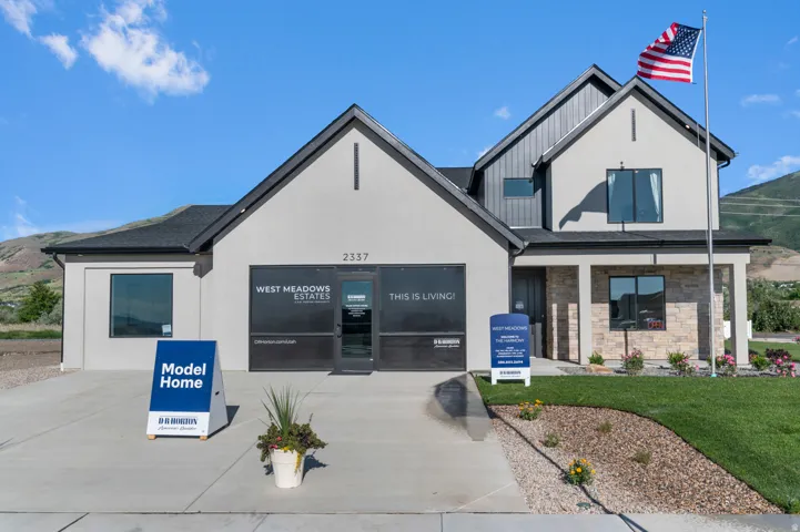 Contemporary exterior with a stone facade accent, stucco siding, and a gabled roofline