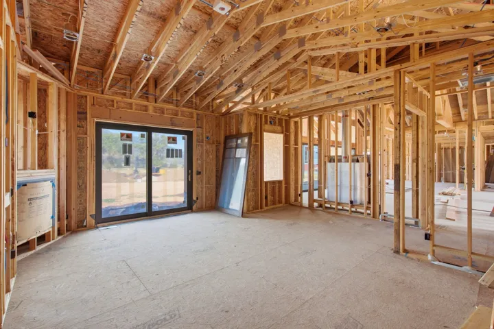 Primary bedroom with vaulted ceiling, sliding glass door to the covered patio, and gas fireplace.